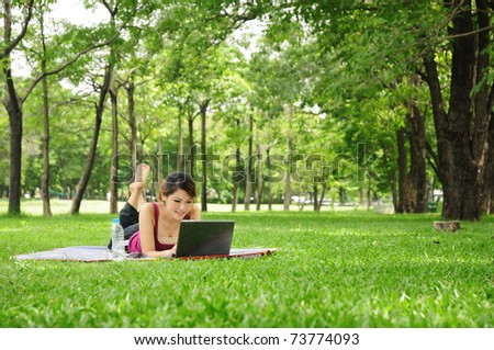 Young woman using laptop in the park Royalty-Free Stock Photo #73774093
