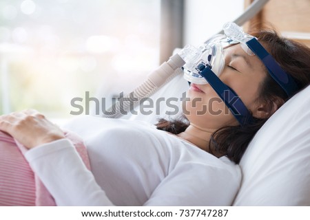 Senior woman using cpap machine to stop choking and snoring from obstructive sleep apnea with bokeh and morning backlighting background.
Woman and cpap mask, healthcare concept. Royalty-Free Stock Photo #737747287