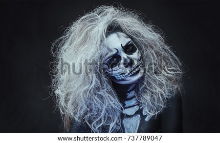 Halloween female skull makeup over dark grey background.