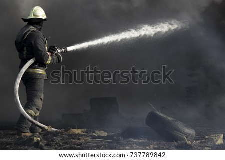 Firefighters extinguishing fire in building in the night Royalty-Free Stock Photo #737789842