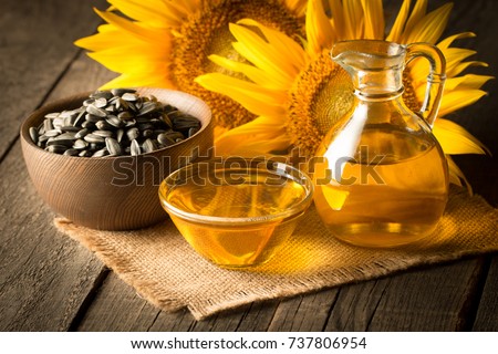 Closeup photo of sunflower oil with seeds on wooden background. Bio and organic product concept. Royalty-Free Stock Photo #737806954