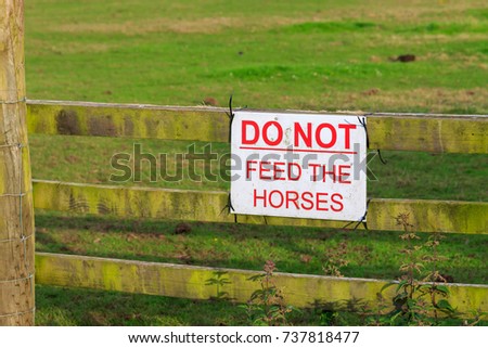 Do Not Feed the horses sign fixed to wooden fence