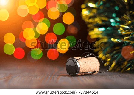 Cork from a bottle of sparkling wine like champagne on a wooden table, Christmas decorations and lights, happy new year and Christmas, celebration 2018
