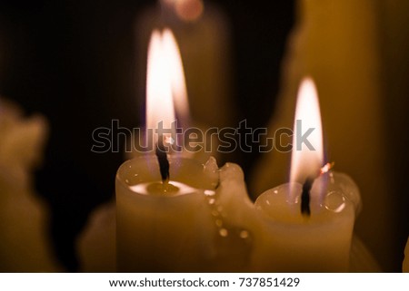 Several candles burn on a black background, isolated image