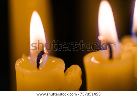 Several candles burn on a black background, isolated image