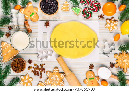 Cooking Christmas gingerbread cookies with the ingredients, dough, candy and winter spices decorating for new year celebration on white wooden table. Xmas food background