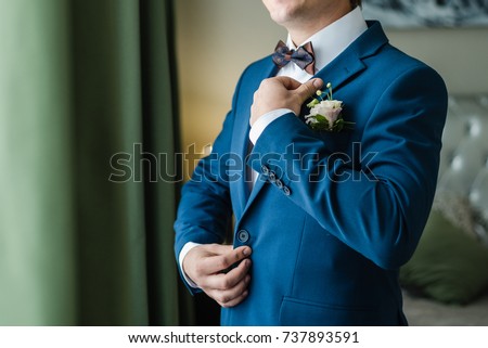 the groom adjusts his jacket, groom in a jacket, The morning of the groom Royalty-Free Stock Photo #737893591