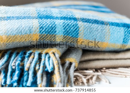Stack of woolen checked blankets, autumn and winter concept
