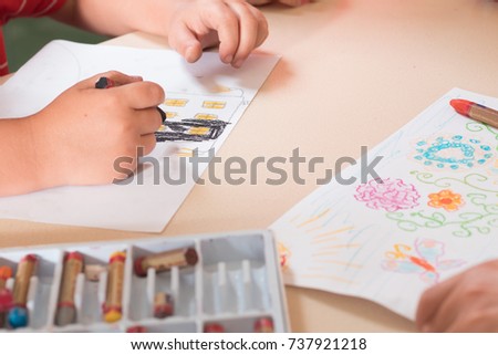 children's drawings, hands and albums with pencils on the table