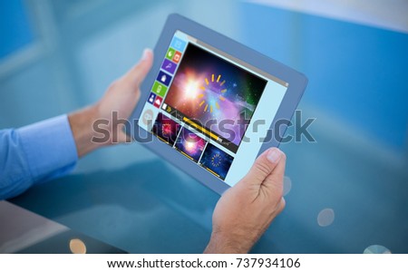 Businessman using his tablet  against composite image of various video and computer icons
