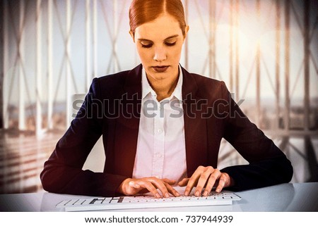 Businesswoman typing on keyboard at desk against aerial view of new york 