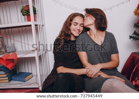 Mom and daughter decorate Christmas tree exchanging gifts taking pictures and having fun