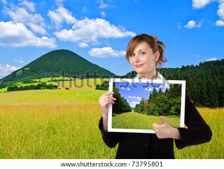 Business woman holding image, in nature