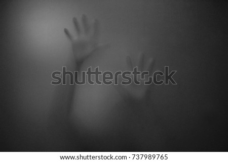 shadow of hands behind frosted glass