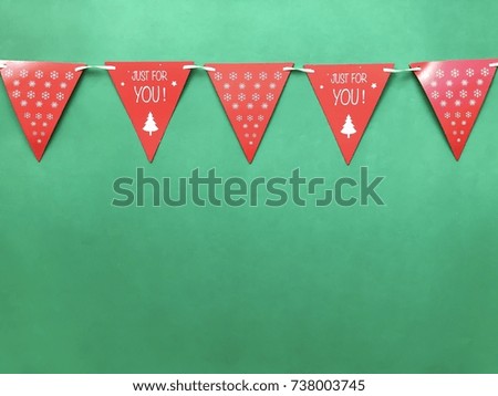 Closeup red Christmas flag rail set on green background.The concept of Xmas celebration, Christmas party,greeting season,Christmas decoration.Top view .Copy space.Selective focus.