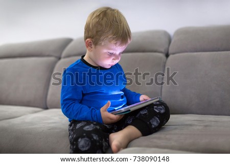 Little toddler boy watch cartoons on the tablet