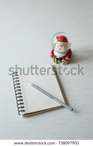A notebook and a pencil are ready for a letter to Santa Claus. Christmas mood is to write letter or to draw a picture to make dreams come true.