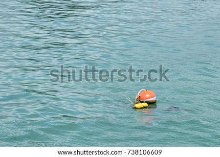 Background of an orange ball buoy floating in the sea