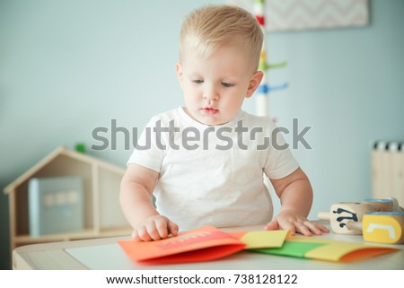 Cute boy with handmade greeting card at home