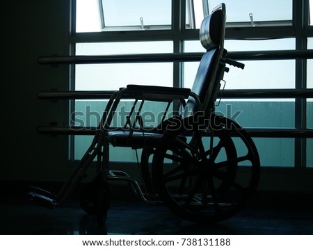 Silhouette of empty wheelchair parked in hospital hallway