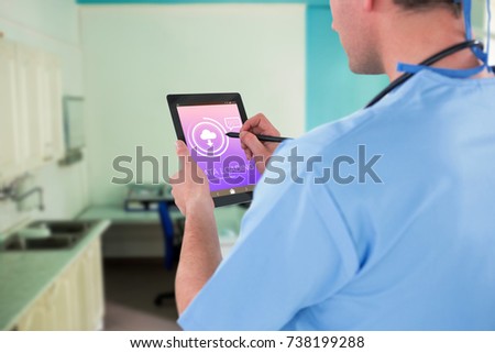 Surgeon using digital tablet  against data loading text with download symbol