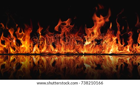 The texture of fire on a black background is reflected in a glossy table. Royalty-Free Stock Photo #738210166