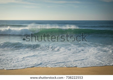surfer swimming breaking wave coming to shore on sandy beach of atlantic coast, capbreton, france