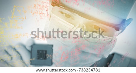 Close-up of female surgeon holding processor against grey background