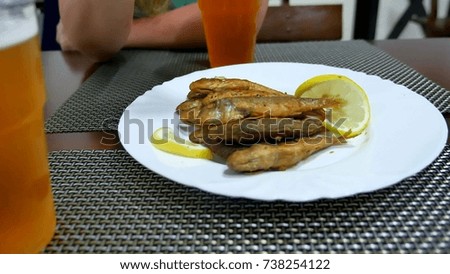Fried surmullet fish on a plate with lemon. Delicious dinner