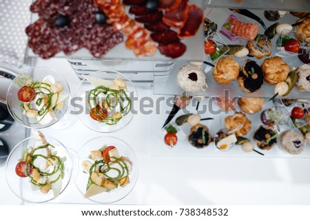 Served dishes to the table for holiday. Cutlery and food on white tablecloths in the restaurant. Design a festive Banquet. Luxurious food for guests and visitors.