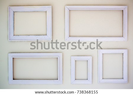 Blank white photo frames hang on the white cement wall. many photo frames on the white background. image for background, wallpaper,decorate and copy space.