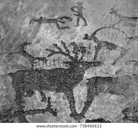 Cave painting. Figure animals and male hunter on stone wall of cave paint ocher ancient prehistoric Neanderthal. prehistoric animal, stone age hunting for deer with big horn