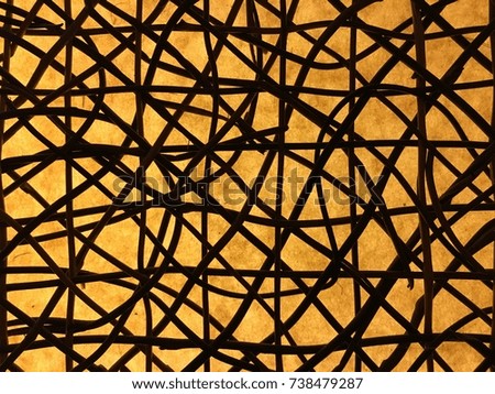 Intertwined twigs against a paper screen illuminated from behind