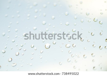 White fuzzy blurred texture with colored impregnation and random water drops light blue edition with white clouds background 