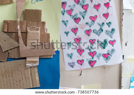 drawing of children on paper and cardboard. colorful drawing colorful hearts hanging on a bulletin board