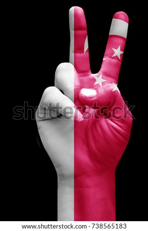 and making victory sign, Singapore painted with flag as symbol of victory, win, success - isolated on black background