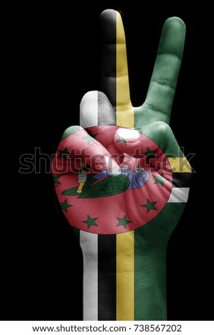 and making victory sign, Dominica painted with flag as symbol of victory, win, success - isolated on black background