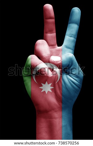 and making victory sign, Azerbaijan painted with flag as symbol of victory, win, success - isolated on black background