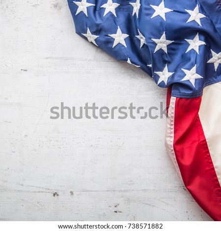Top of view American flag freely lying on white concrete background.