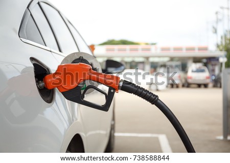 Closeup of woman pumping gasoline fuel in car at gas station. Petrol or gasoline being pumped into a motor vehicle car. Royalty-Free Stock Photo #738588844