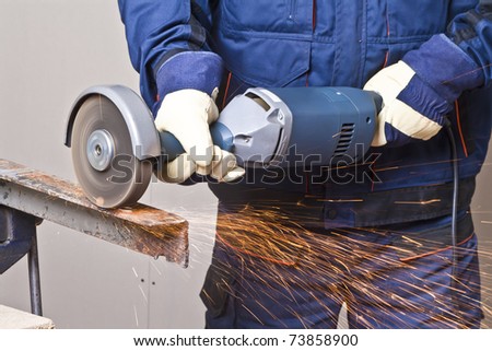 A man working with grinder, close up on tool, hands and sparks, real situation picture