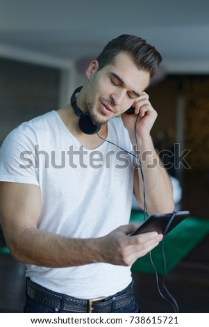 Casual caucasian man listening music by tablet and headphones