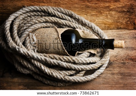 bottle wrapped with rope against a wooden board