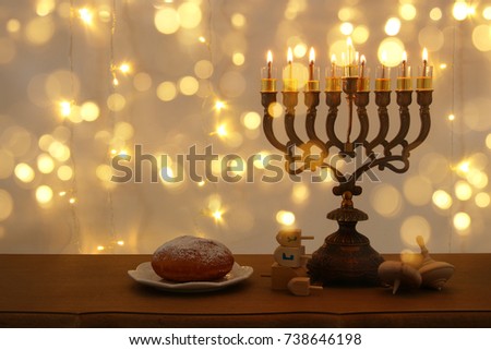 Image of jewish holiday Hanukkah background with traditional spinnig top, menorah (traditional candelabra) and burning candles
