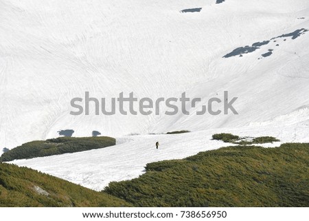 Camera man trekking with snow mountain background at Tateyama Japan alpine