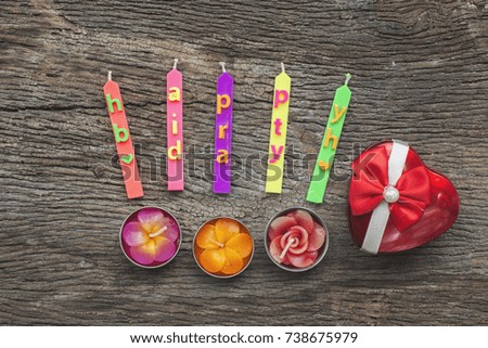 Candle-shaped flowers, heart-shaped boxes on the old wooden floor. Concept Happy birthday to you.