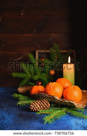 Traditional Russian still life for the new year, with manadrinas, a Christmas tree, candles, a dark background, a copy of the space