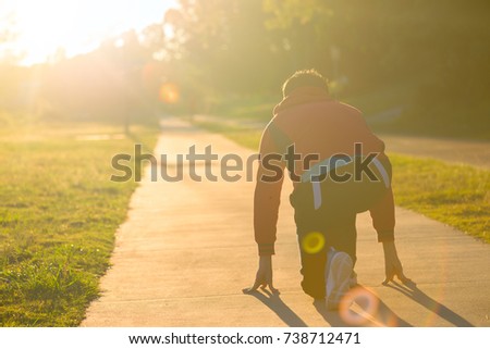 A runner athletic is  starting for running in the early morning with the silhouette scence. 