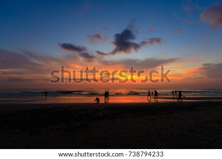 Silhouette people at the sunset beach with orange sky with beautiful blue, evening time.