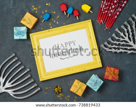 Hanukkah background with photo frame, menorah and gift box over blackboard. View from above. Flat lay